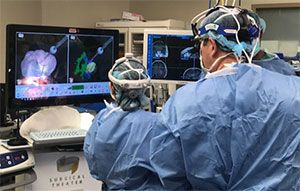 Health providers looking at data on screens, wearing their surgery gowns 