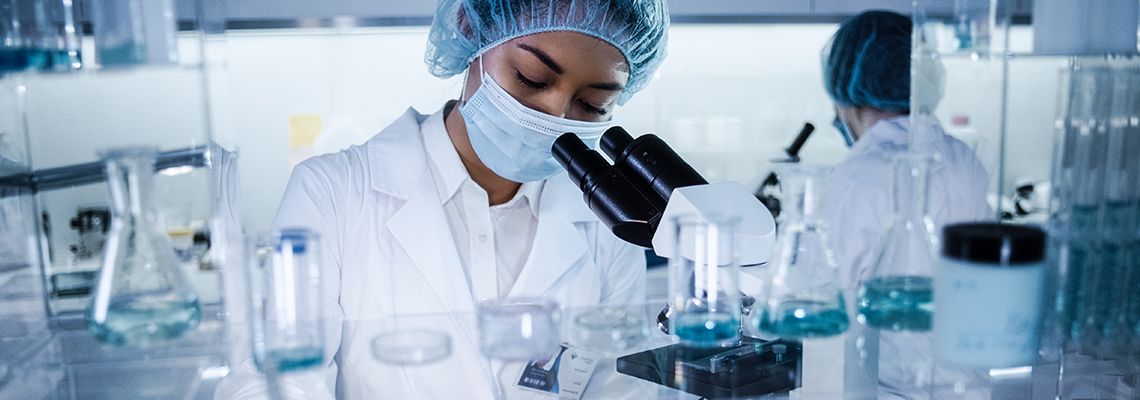 Scientist looking through microscope in a lab