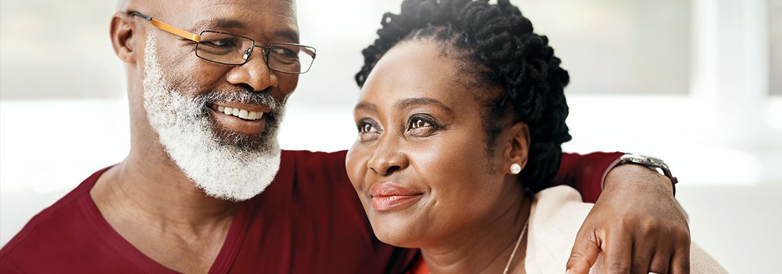 Elderly couple with their arms around each other