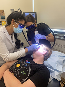 Two medical professionals perform a treatment for vascular birthmarks on a patient.