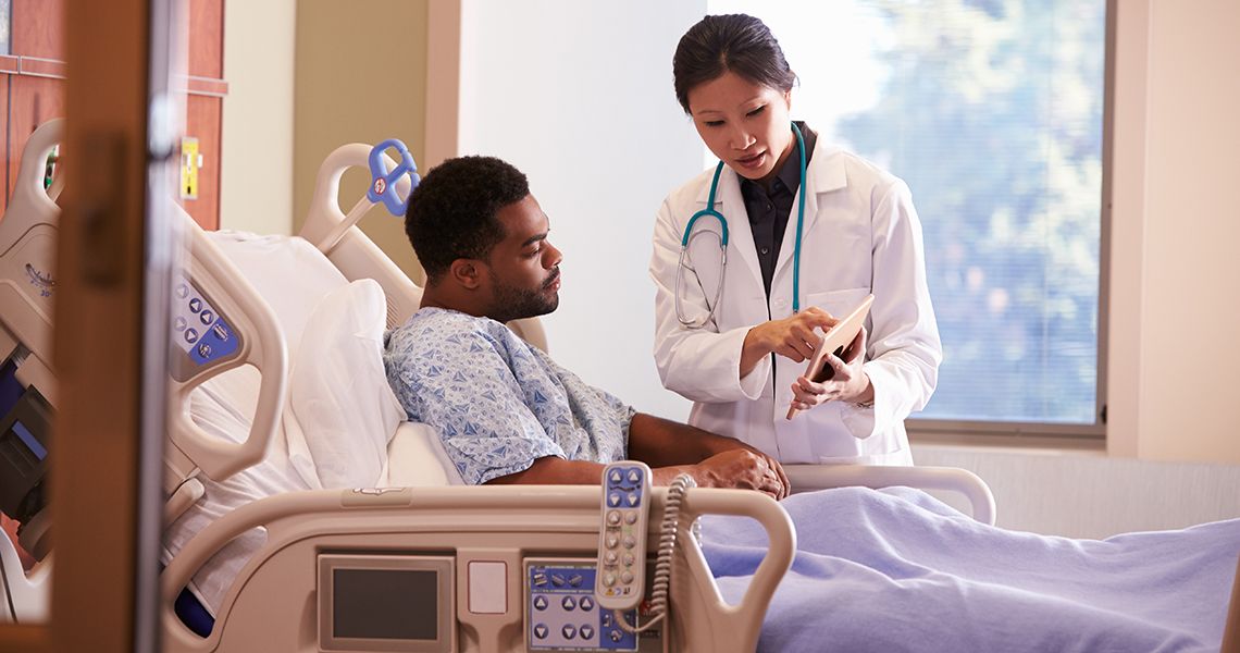 Doctor talking to a patient who is in a hospital bed