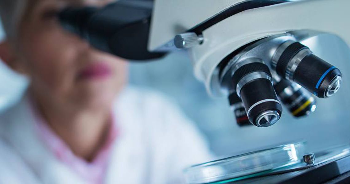 Scientist looking through a microscope