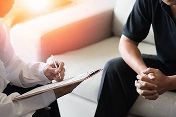 doctor talking to patient and writing on a clipboard