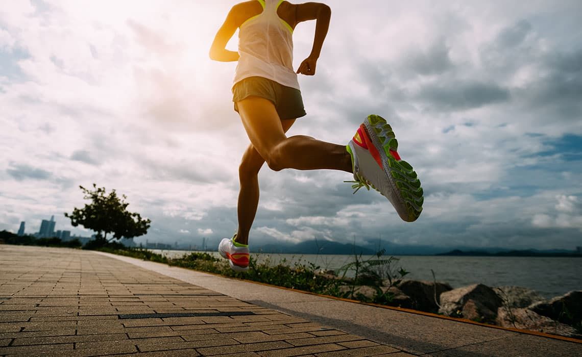 A runner running alongside a body of water