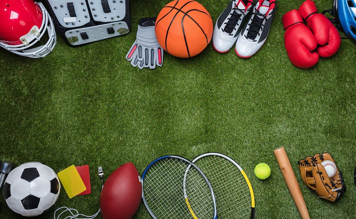 Various sports equipment laying on a turf field