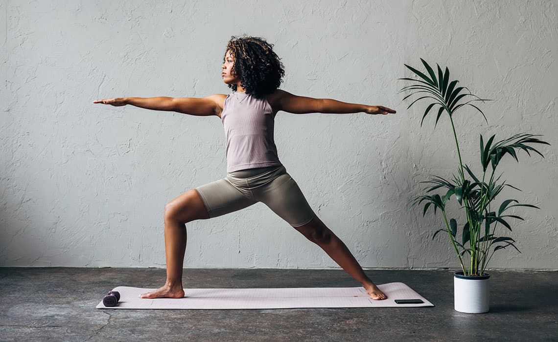 A woman doing a yoga pose on a mat