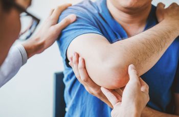 Health Provider checking a patient’s elbow