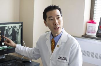 Andrew Choi pointing to a computer screen